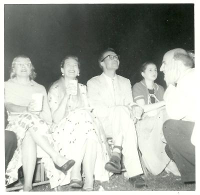 Dave Brubeck and Iola Brubeck (seated), George Avakian (kneeling), 2 unidentified women (seated) listening to concert at Newport Jazz Festival (Newport, Rhode Island)