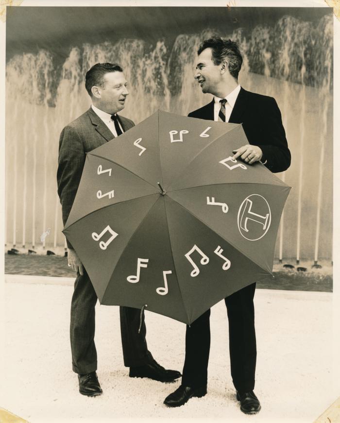 Dave Brubeck with unnamed Traveler's Insurance representative holding an umbrella with music notes on it at The New York World's Fair (New York City, New York)