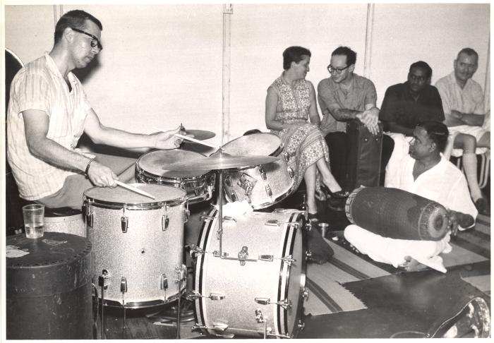 Joe Morello performing with unidentified mridangam player, Rachel Wiggin chatting with Paul Desmond in background (Madras, India)