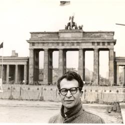 Dave Brubeck wearing an overcoat and glasses at the Brandenburg Gate (Berlin Wall, Berlin, West Germany)