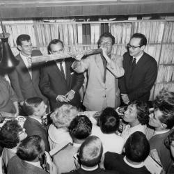 Dave Brubeck blowing on a didjeridoo; Paul Desmond looks on with amusement (Brash's Music Store, Melbourne, Australia)