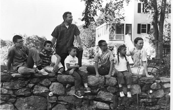 Dave Brubeck, Darius Brubeck, Chris Brubeck, Dan Brubeck, Michael Brubeck, Catherine Brubeck, Iola Brubeck sitting on stone wall at at Irving Townsend house (Wilton, Connecticut)