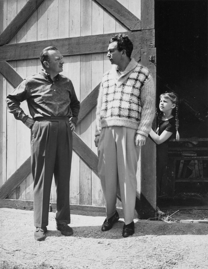 Walter Cronkite and Dave Brubeck standing at the barn door while Catherine Brubeck peers out from behind during filming of an episode of CBS television show "The 20th Century" at Dave Brubeck's home (Wilton, Connecticut)