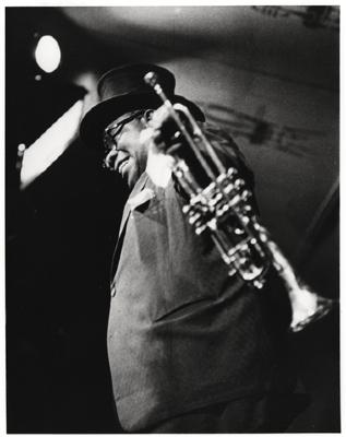 Louis Armstrong with top hat and trumpet at rehearsal or performance of "The Real Ambassadors" (Monterey Jazz Festival, Monterey, California)