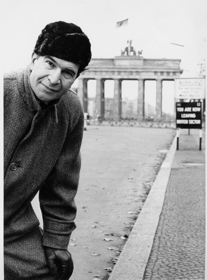 Dave Brubeck wearing an overcoat, hat, and gloves at the Brandenburg Gate (Berlin Wall, Berlin, West Germany)