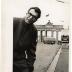 Dave Brubeck wearing an overcoat, gloves, and glasses at the Brandenburg Gate (Berlin Wall, Berlin, West Germany)