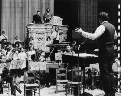 Dave Brubeck standing at piano, Cantor Harold Orbach, McHenry Boatwright singing, R. Wayne Dirksen conducting orchestra rehearsing "Gates of Justice" (National Cathedral, Washington, D.C.)