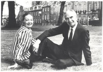 Dave Brubeck, Iola Brubeck seated on grass in front of brick buildings